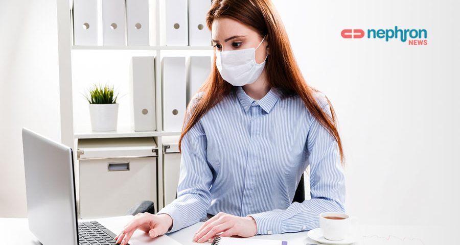 νεαρή γυναίκα δουλεύει στον υπολογιστη φορώντας μάσκα