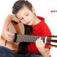 αγόρι με κόκκινη μπλούζα παίζει κιθάρα